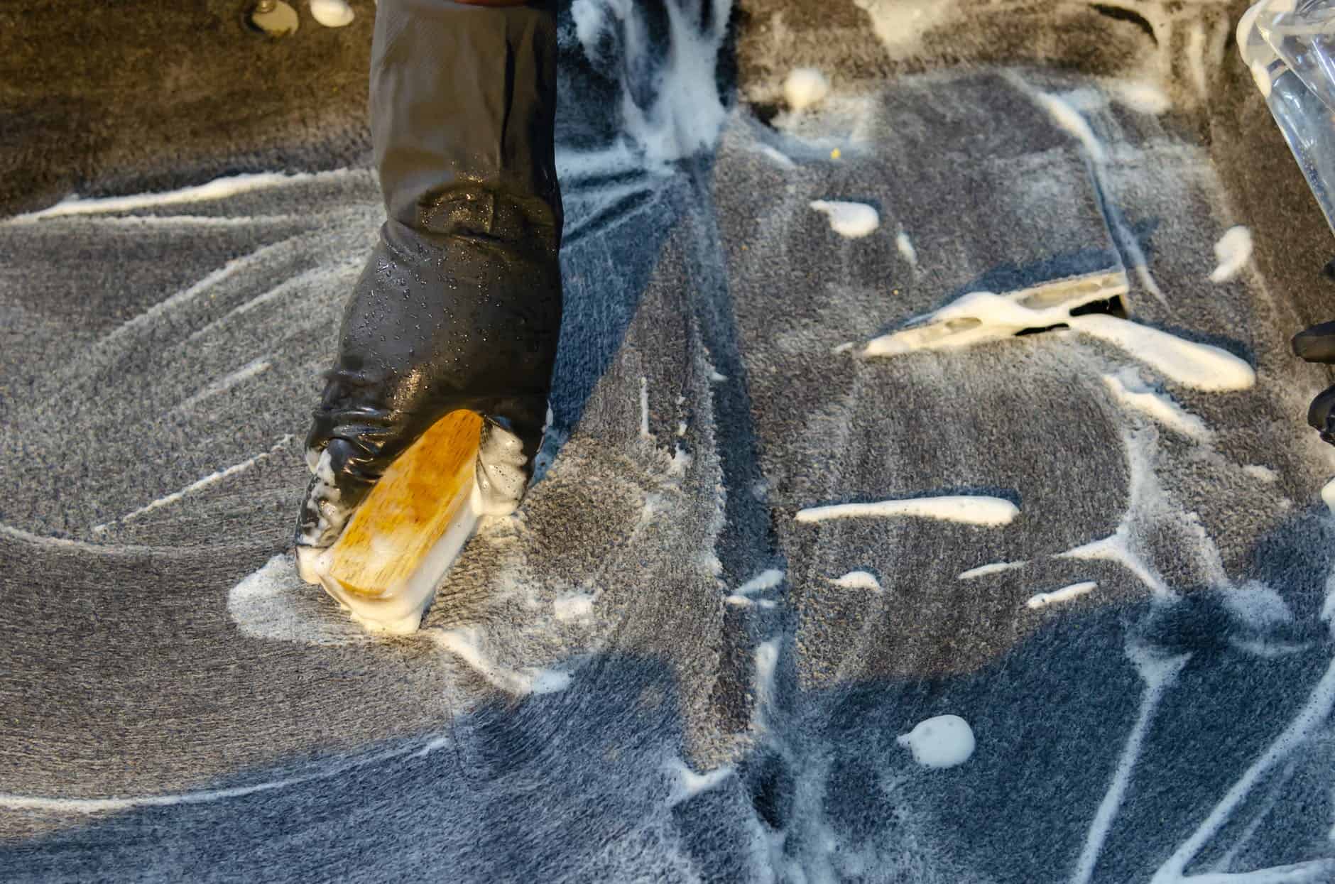 person in blue denim jeans and brown leather boots standing on gray sand