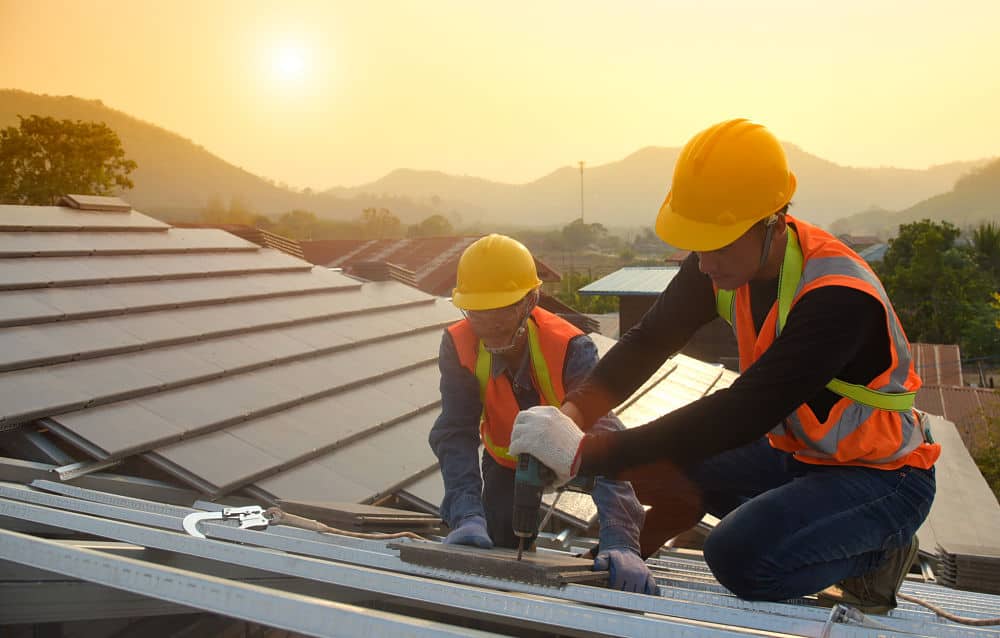 Construction Industry. Roofer with Ceramic Tiles in Hands. Roof Worker Closeup. House Rooftop Covering Roof construction.
