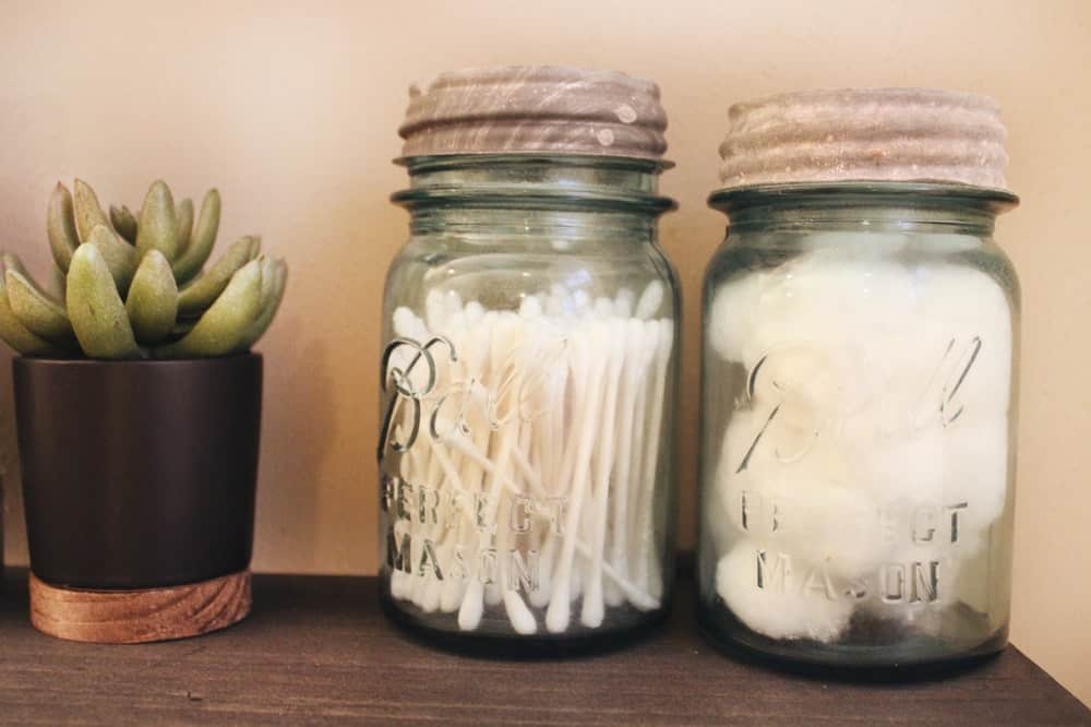 Repurposed jars holding cotton wool and cotton buds