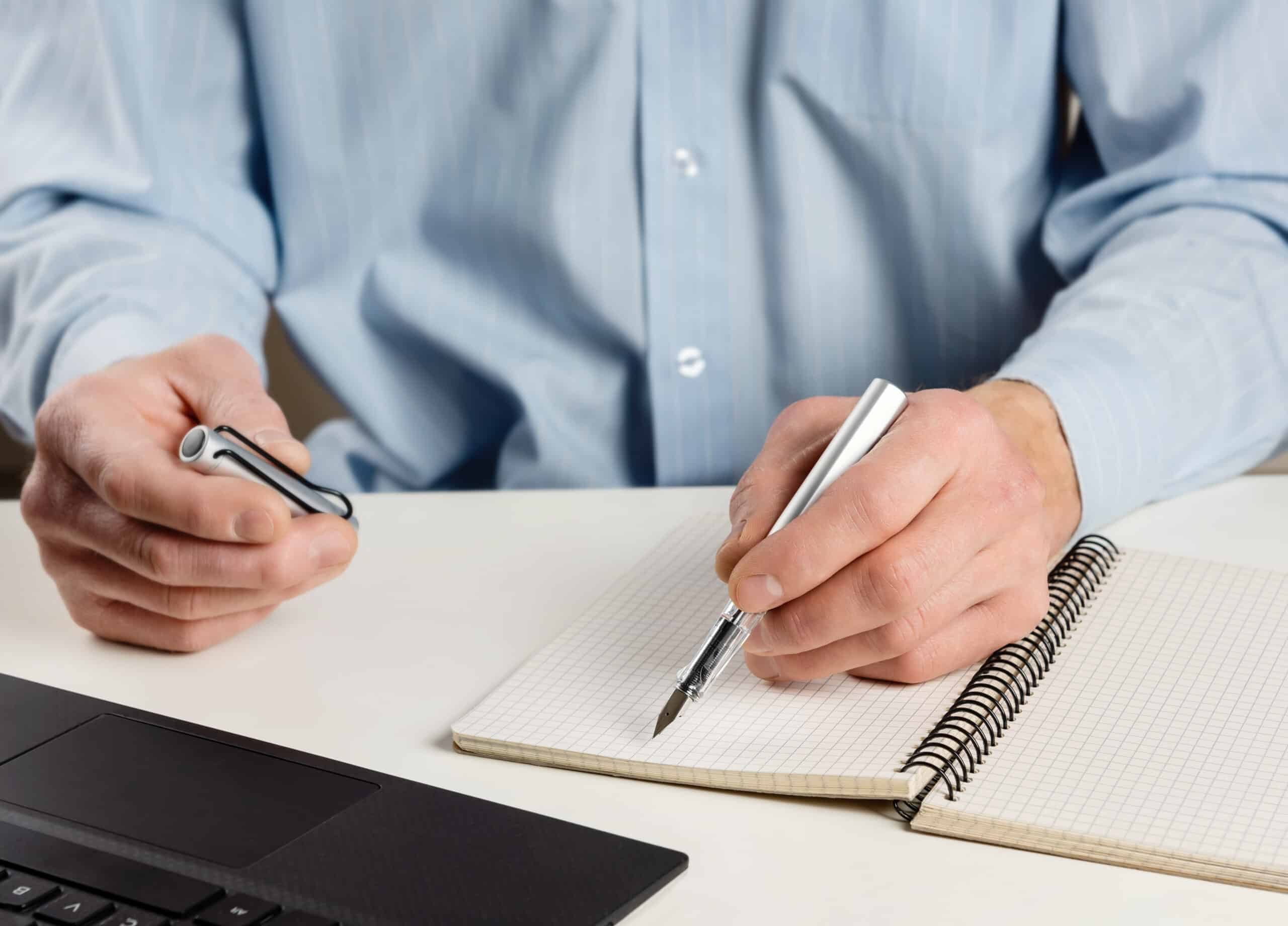 Man at the computer with an ink pen.